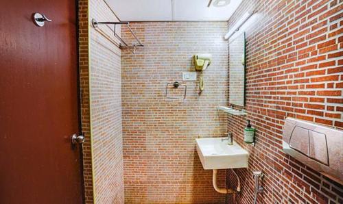 a bathroom with a sink and a brick wall at FabHotel Earth - Nr Guindy Industrial Estate in Chennai