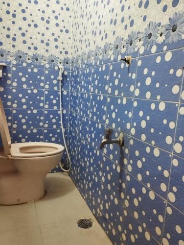 a bathroom with a toilet with a polka dot wall at Hotel Al-Hayat Abasik in Dhaka