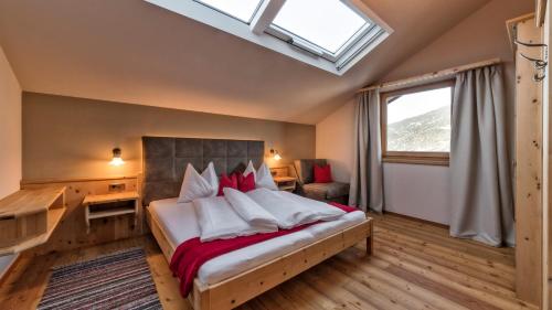 1 dormitorio con cama, escritorio y ventana en Widmannhof - Urlaub auf dem Biobauernhof, en Bresanona
