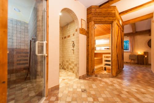 baño con ducha a ras de suelo y puerta de cristal en Sonnleiten Sonnenparadies en Collepietra