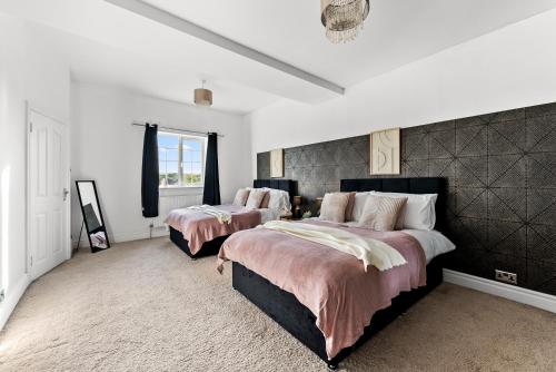Duas camas num quarto com paredes brancas em Stunning 4 Bed House - Sleeps 12 em Cheltenham