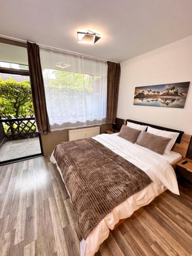 a bedroom with a large bed and a large window at Wandertraum im Zentrum Bad Aussee in Bad Aussee