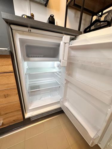 um frigorífico vazio com a porta aberta numa cozinha em Urlaub im Herzen von Bad Aussee em Bad Aussee