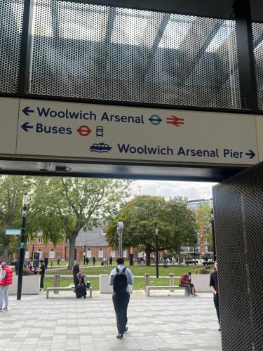 a sign in a park with people walking around at Spacious 2 Bedroom Apartment in Woolwich Arsenal in Woolwich