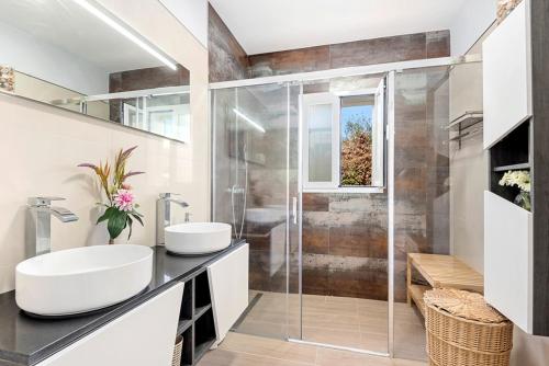 ein Bad mit einer Glasdusche und einem Waschbecken in der Unterkunft Villa Caterina - Punta Prima in Punta Prima