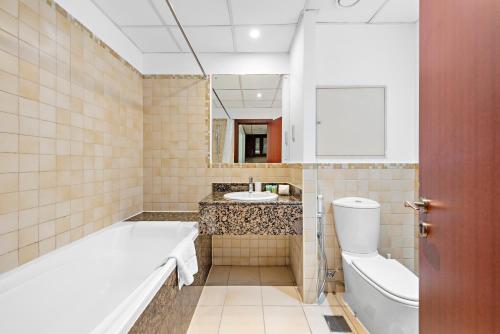 y baño con bañera, aseo y lavamanos. en Serene Studio APT Rimal 3 JBR, en Dubái