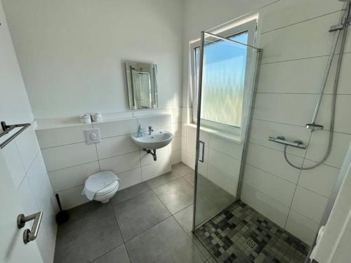 uma casa de banho com um chuveiro, um WC e um lavatório. em moderne und schicke Unterkunft in Zeestow - jedes Schlafzimmer verfügt über ein eigenes Bad em Brieselang