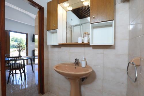 a bathroom with a sink and a mirror and a table at Small stone house in a quiet place island Solta in Stomorska