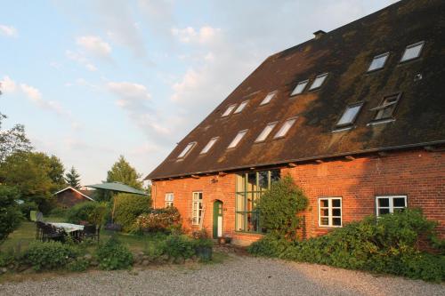 ein großes rotes Backsteingebäude mit einem Dach in der Unterkunft Das Abendrote Haus in Gömnitz