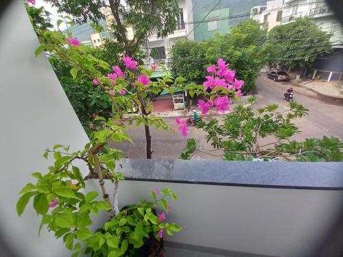 a view from a balcony with pink flowers at Chang Homestay in Quy Nhon