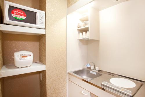 una piccola cucina con lavandino e forno a microonde di Hotel Hanabi - Vacation STAY 62608v a Tokyo