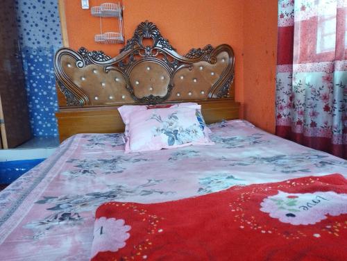 ダッカにあるHotel Al-Hayat Abasikのベッド(華やかなヘッドボード、赤毛布付)