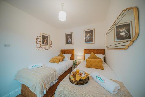 2 aparte bedden in een kamer met een spiegel bij Spacious Heart of town w/garden WiFi Smart TV in Cirencester