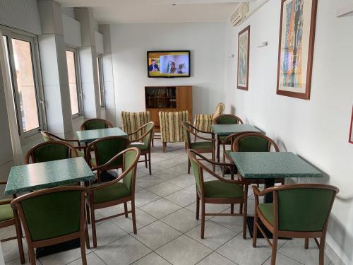 una sala da pranzo con tavoli e sedie verdi di Hotel Ornella a Lido di Jesolo