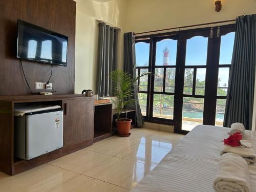 Habitación con cama y TV. en The Ocean Park Beach Resort, en Kovalam