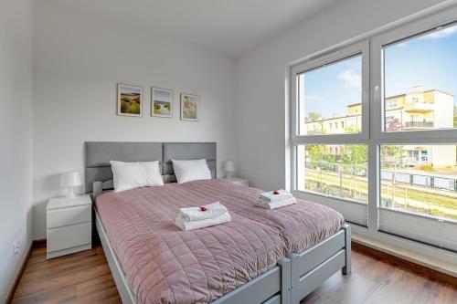 a bedroom with a large bed with two towels on it at Apartment Brzeźno Beach by TriApart in Gdańsk