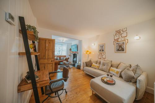 een woonkamer met een bank en een tafel bij Spacious Heart of town w/garden WiFi Smart TV in Cirencester