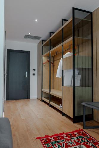 a living room with wooden shelves and a door at Hotel Uji Ftohte Tepelene in Tepelenë