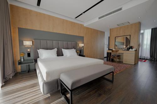 a bedroom with a large bed and a desk at Hotel Uji Ftohte Tepelene in Tepelenë