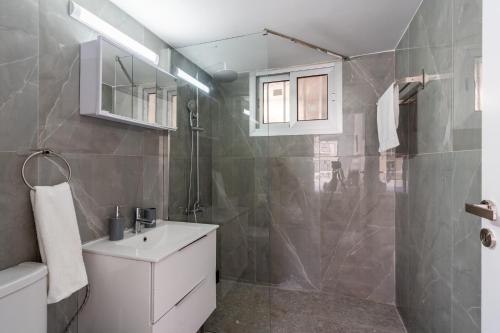 bagno con lavandino bianco e doccia di Powder’s 1-Bedroom Retreat in Mackenzy, Larnaca a Larnaka