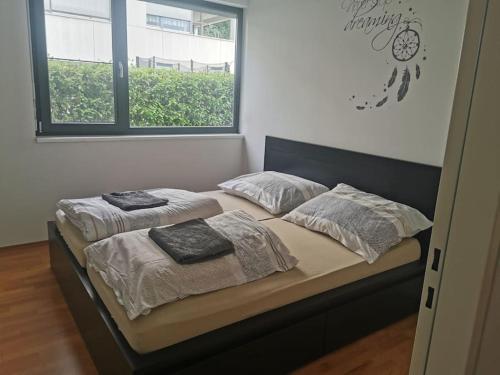 ein Bett mit zwei Kissen auf einem Zimmer in der Unterkunft Wunderschöner Aufenthaltsort in Bregenz