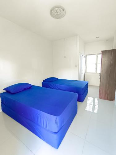 two blue beds in a white room with a ceiling at Ln House Chiang Mai in Chiang Mai