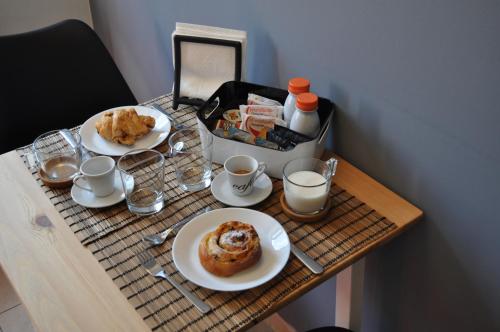a table with two plates of food and cups of coffee at BaCar b&b in Quattromiglia