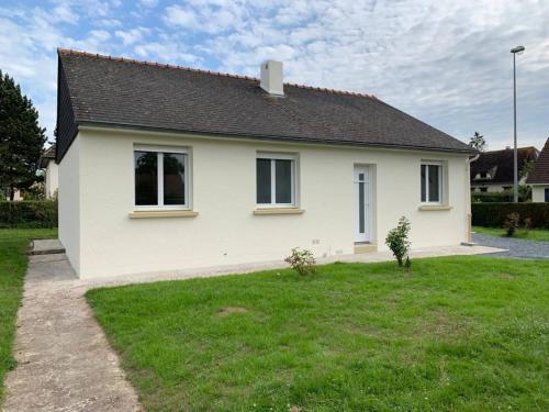 uma casa branca com um relvado verde em frente em Maison 4/6 personnes à Bayeux em Bayeux
