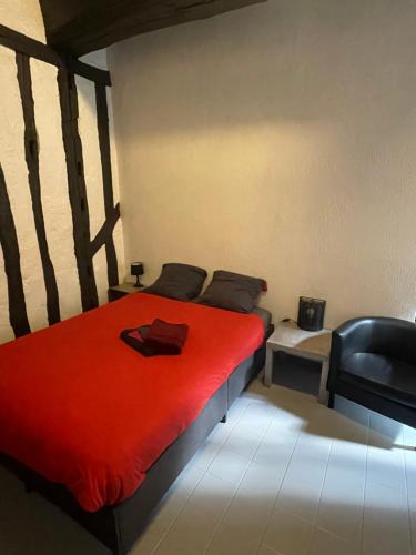 a bedroom with a red bed and a chair at Le Mustang Internet Fibre Netflix in Joigny