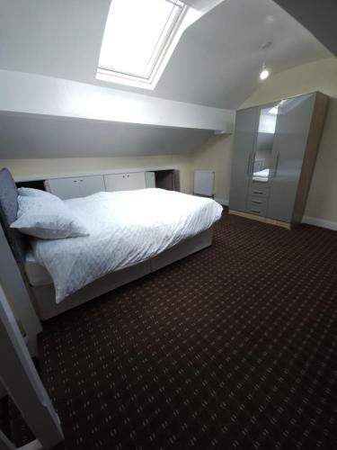 a bedroom with a white bed and a skylight at Stylish property near town centre in Tyldesley