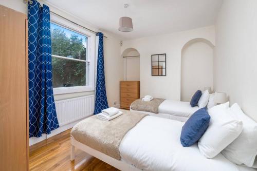 倫敦的住宿－Cottage by Cutty Sark, Greenwich，一间卧室设有两张床和窗户。