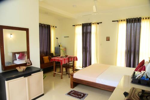 Un dormitorio con una cama, una mesa y un espejo. en THE FREEDOM, en Hikkaduwa