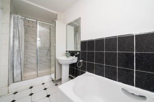 uma casa de banho com uma banheira branca, um lavatório e um WC. em Cottage by Cutty Sark, Greenwich em Londres