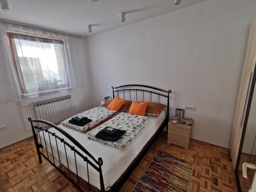 sypialnia z łóżkiem z pomarańczowymi poduszkami w obiekcie Mama w mieście Osijek