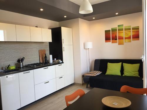 a kitchen and a living room with a couch and a table at Terra di Sicilia in Avola