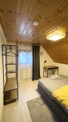 K-Business-Apartments في Oberesslingen: غرفة نوم بسرير وسقف خشبي