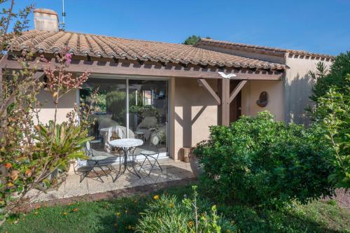a patio of a house with a table and chairs at Préfailles - Maison 6 Pers - 200m des plages in Préfailles