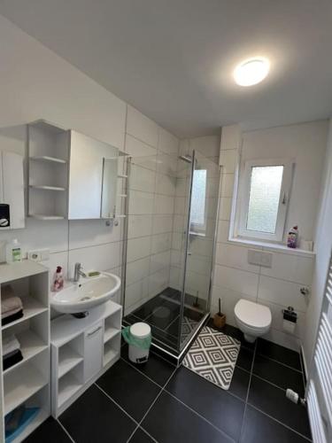 een badkamer met een douche, een wastafel en een toilet bij MG15 Schönes Maisonette Apartment in schöner Lage in Mönchengladbach