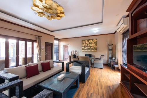 a living room with a couch and a tv at Yotaka Boutique Hotel Bangkok in Bangkok