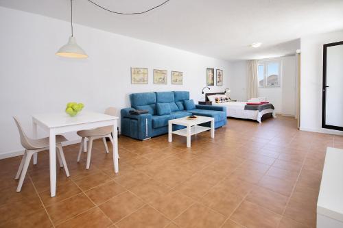 a living room with a blue couch and a table at Peñas Blancas in Mácher