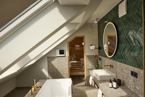 a bathroom with a sink and a mirror at DAS LORNSEN - Serviced Luxury Apartments in Westerland (Sylt)