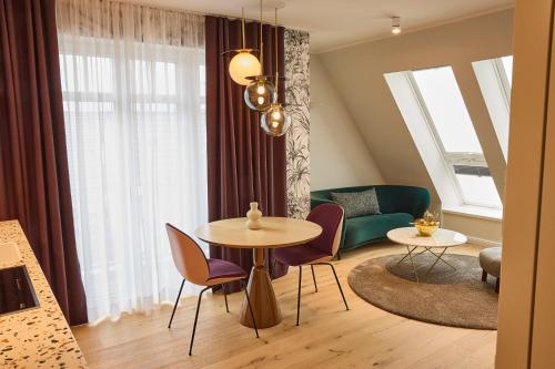 ein Wohnzimmer mit einem Tisch, Stühlen und einem Sofa in der Unterkunft DAS LORNSEN - Serviced Luxury Apartments in Westerland