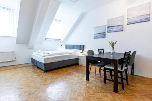 een slaapkamer met een bed en een tafel en stoelen bij ROOFTOP close to Main Station by JR City Apartments in Wenen