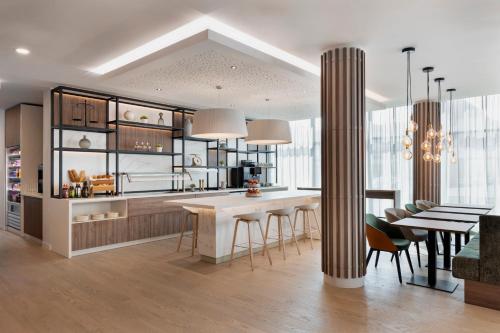 uma cozinha e sala de jantar com mesa e cadeiras em Residence Inn by Marriott Vienna City East em Viena