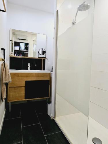ein Bad mit einer Dusche und einem Waschbecken in der Unterkunft Maison chaleureuse à Uzès in Uzès