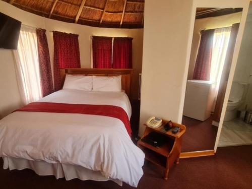 a bedroom with a bed and a telephone in it at Mmelesi Lodge in Maseru