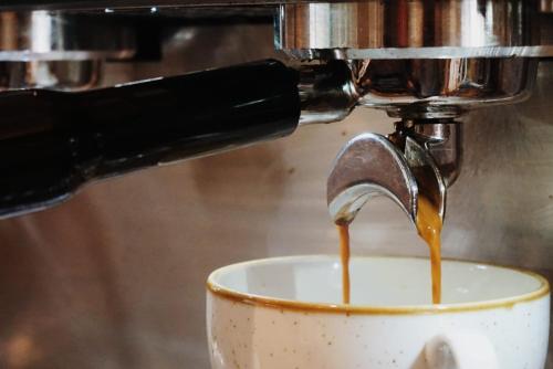 a coffee maker pours coffee into a cup at Upstairs at 33 - Self check in boutique accommodation in Worcester Centre in Worcester