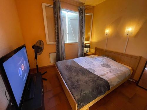 une chambre avec un lit et une télévision à écran plat dans l'établissement Appartement Fréjus, à Fréjus