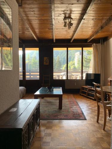 - un salon avec une table et quelques fenêtres dans l'établissement Monoikos, à Uvernet