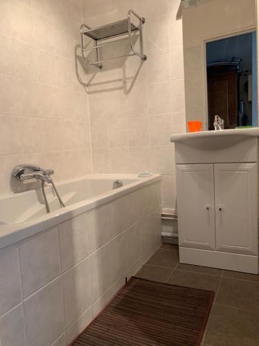 une salle de bain avec une baignoire, un lavabo et un miroir dans l'établissement Monoikos, à Uvernet